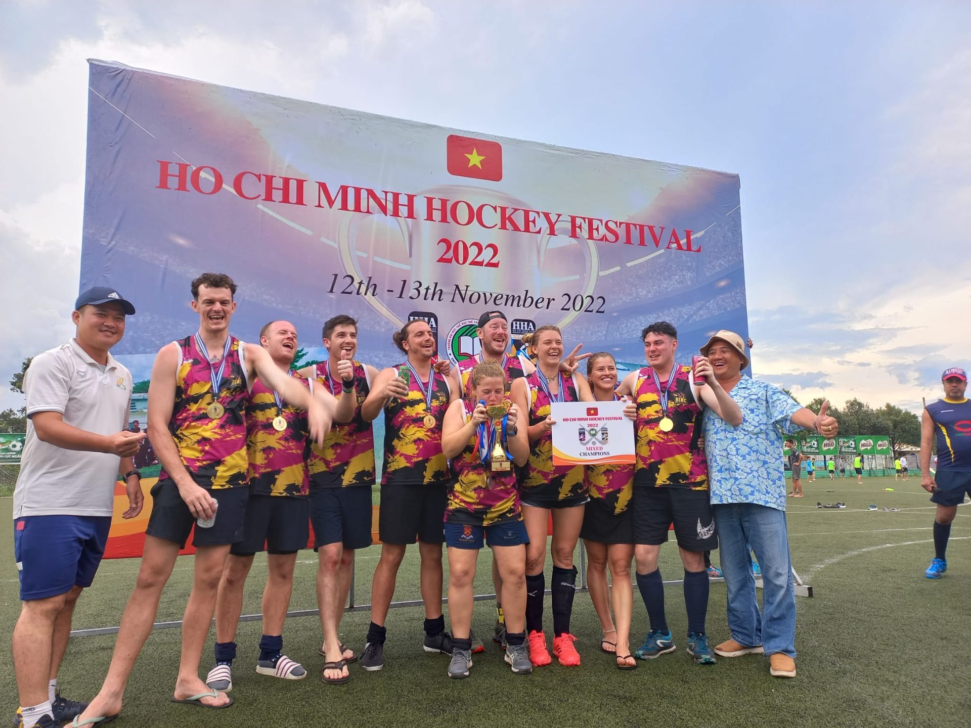 A group of people are posing for a picture on a field.