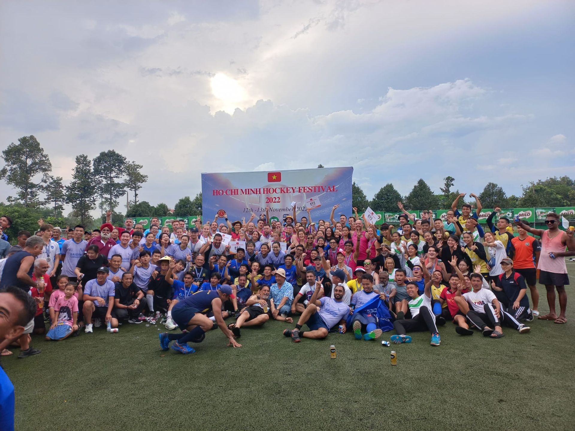 A large group of people are posing for a picture on a field.
