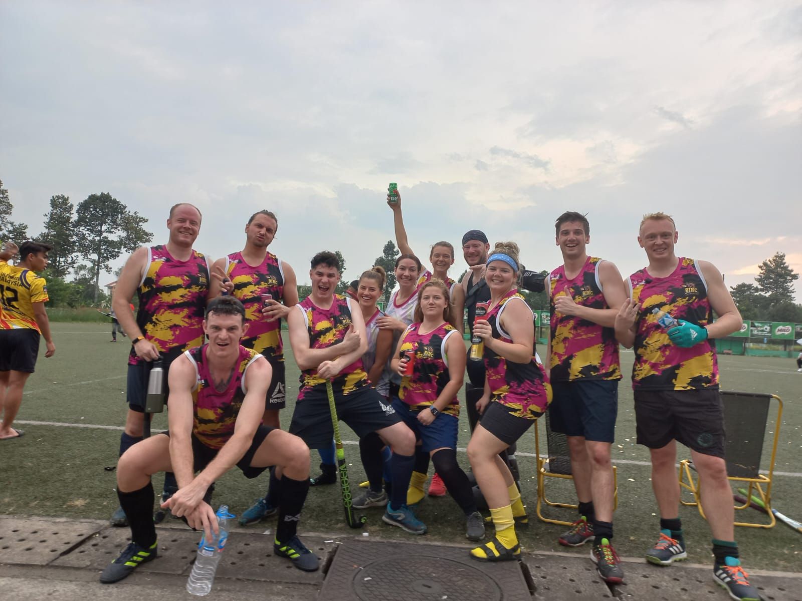 A group of people are posing for a picture on a field.