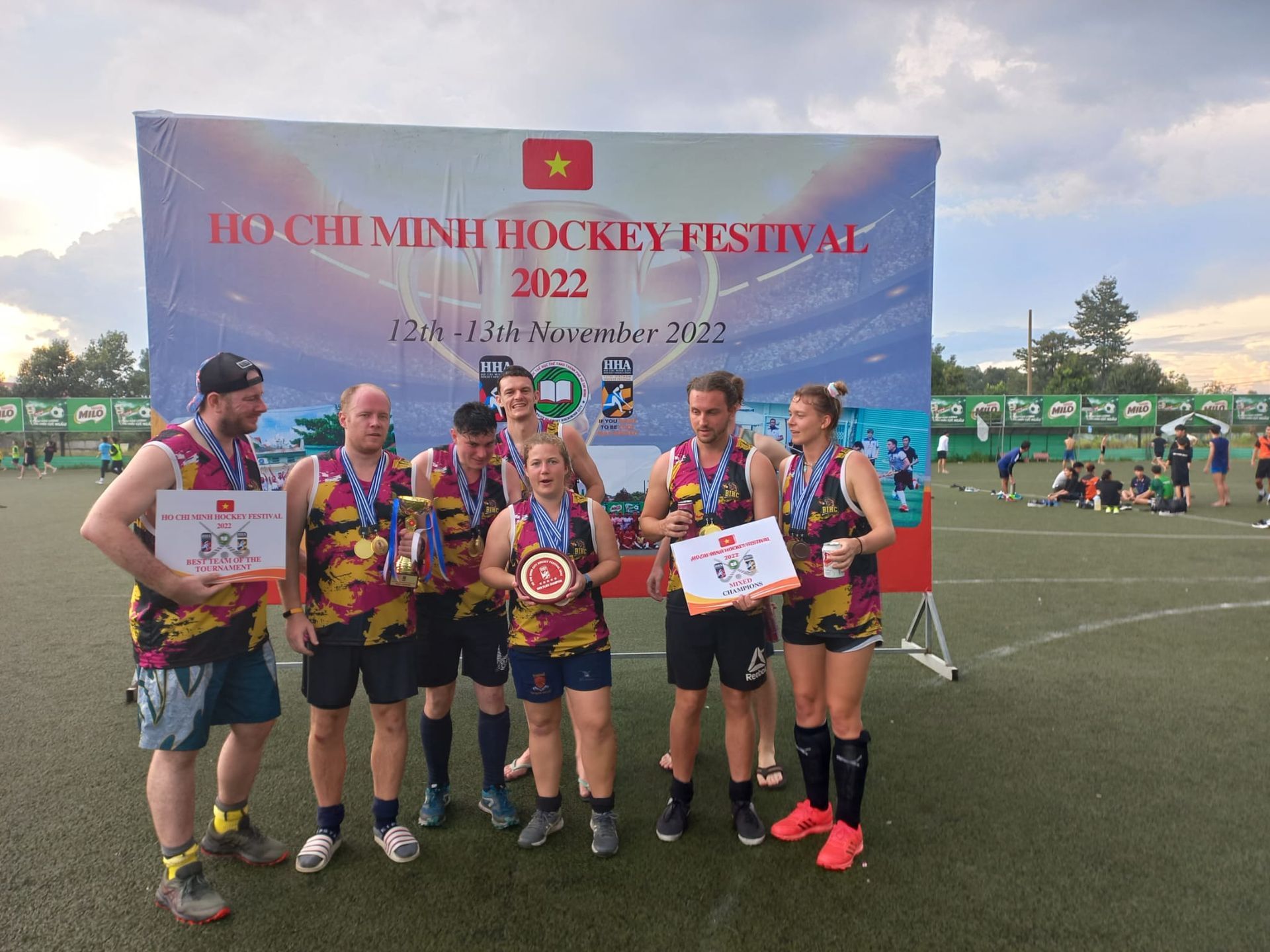 A group of people standing in front of a sign that says hockey festival.