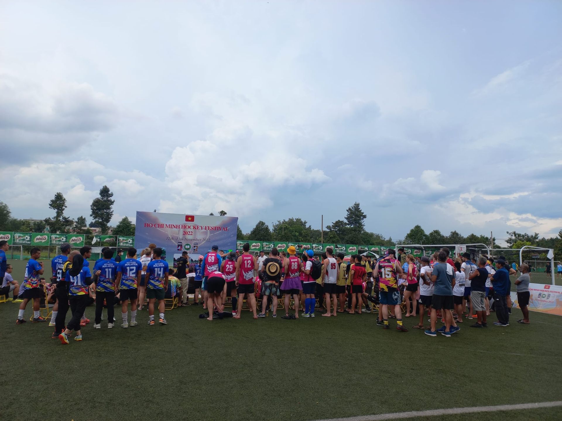 A group of people are standing on top of a soccer field.