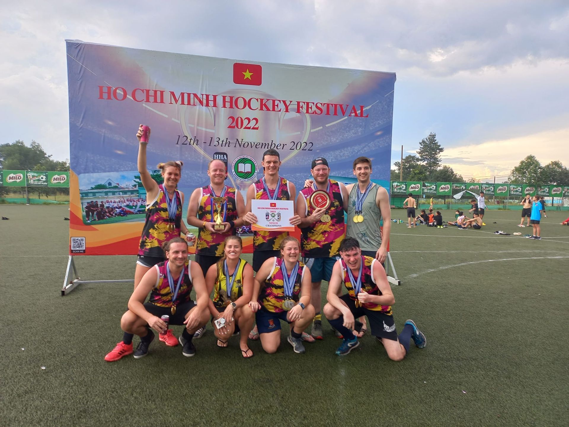 A group of people are posing for a picture on a field.