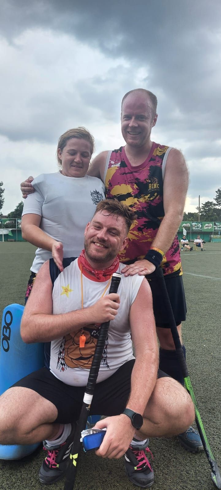 A group of people are posing for a picture on a field.