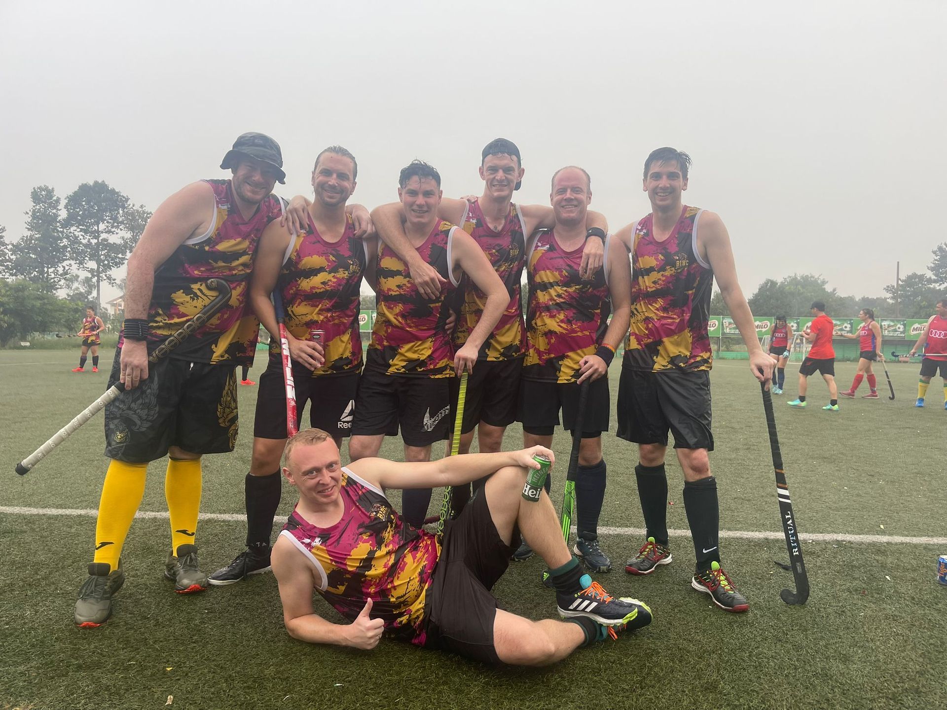 A group of men are posing for a picture on a field.