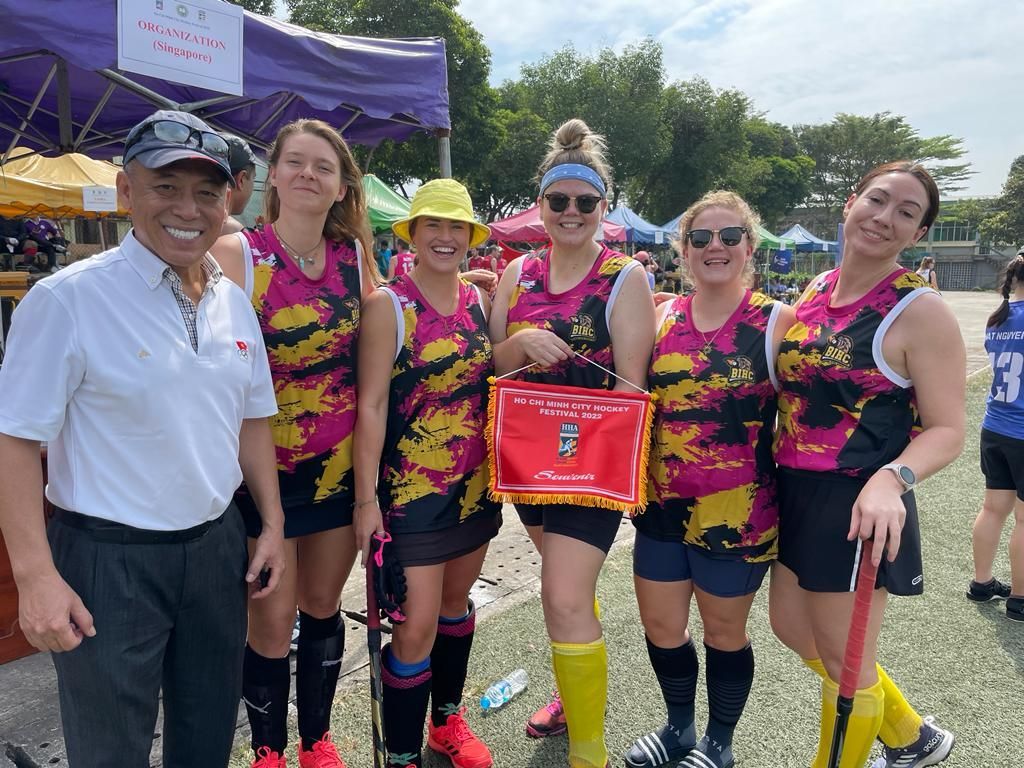 A group of women standing next to each other on a field.