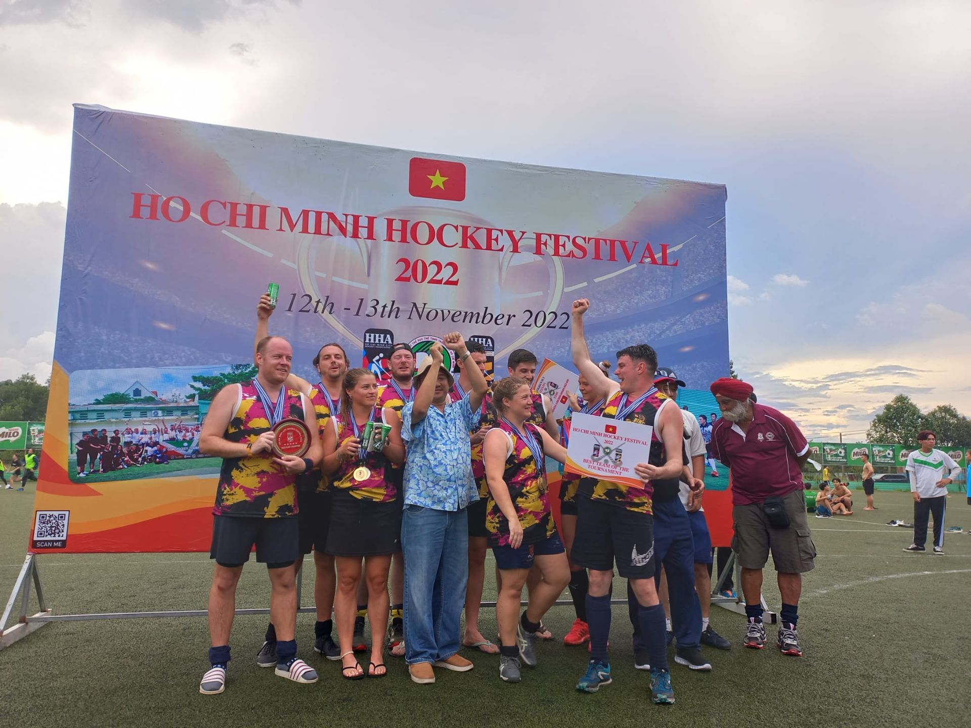 A group of people are standing in front of a sign that says hockey festival.