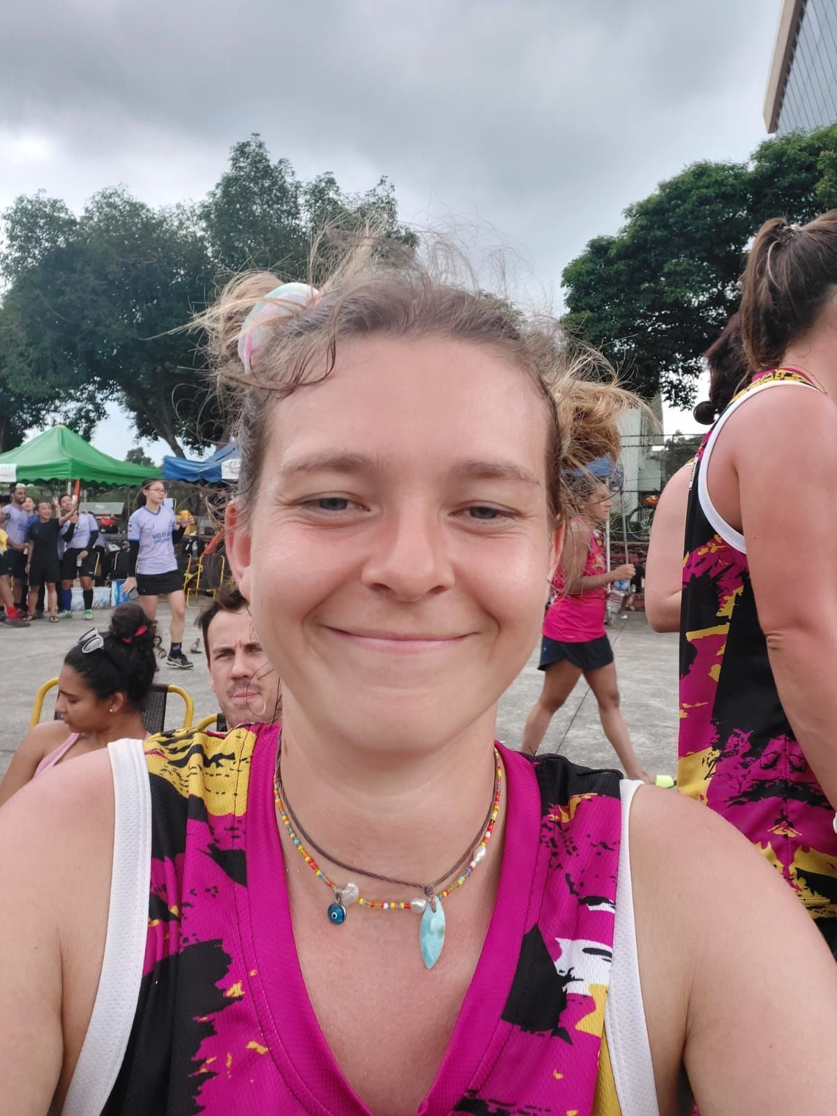 A woman in a pink and black shirt is smiling for the camera.