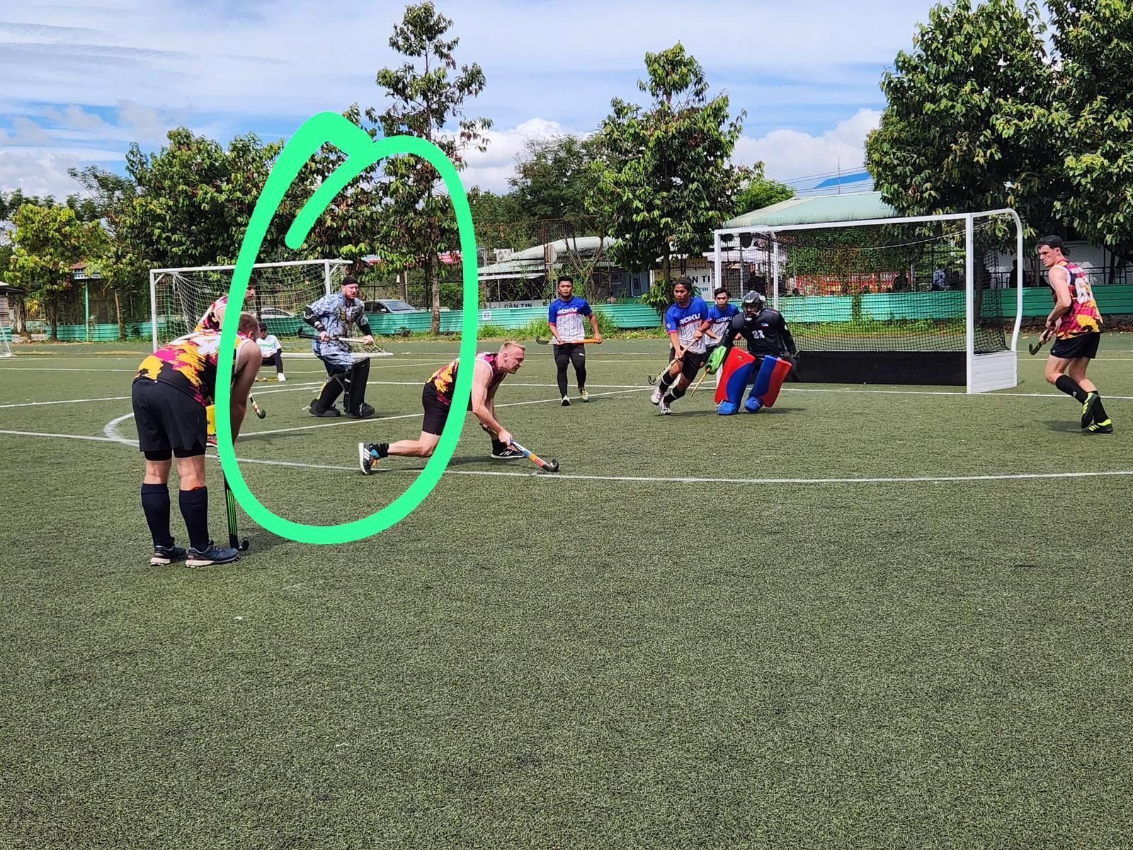 A group of people are playing a game of field hockey on a field.