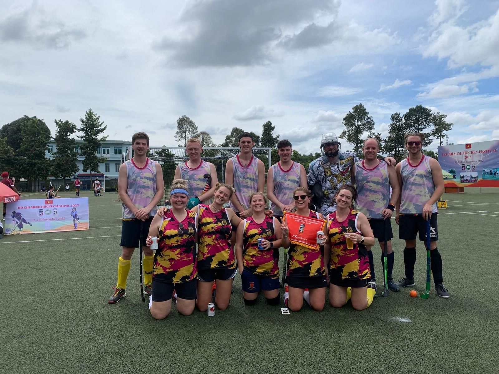 A group of people are posing for a picture on a field.