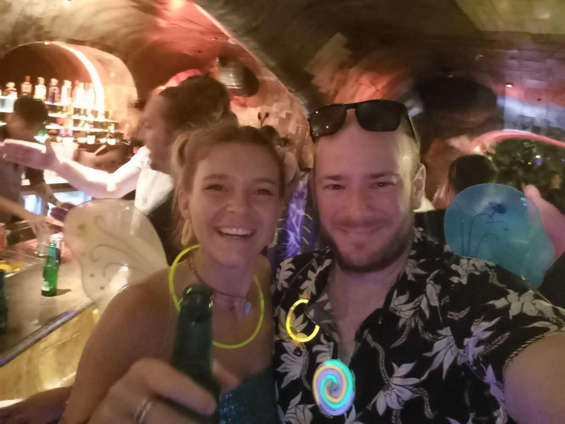 A man and a woman are posing for a picture in a bar