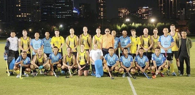 A group of men are posing for a picture on a field.