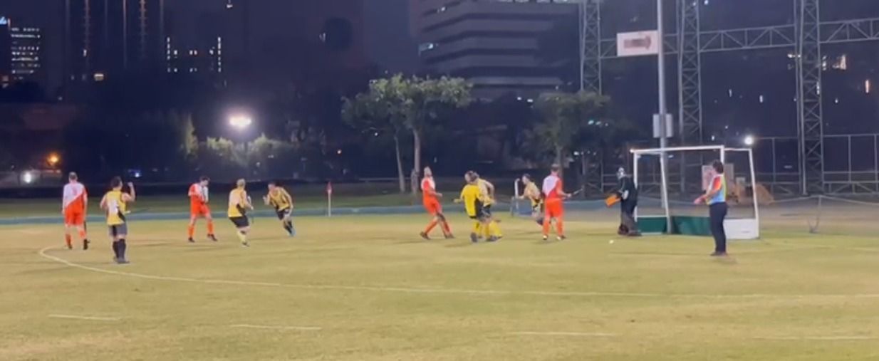 A group of people are playing soccer on a field at night.