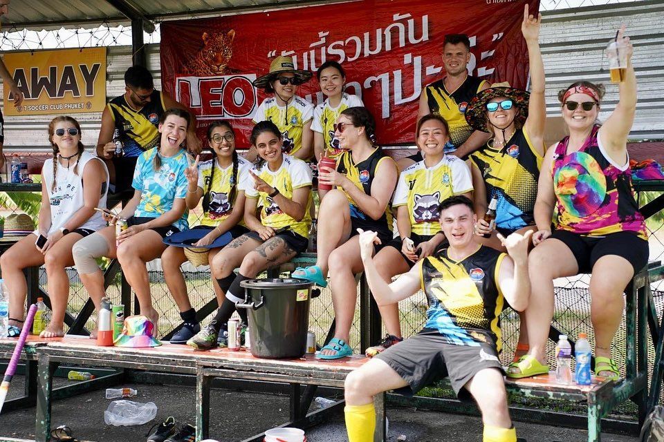 A group of people are sitting on a bench in front of a sign that says away.
