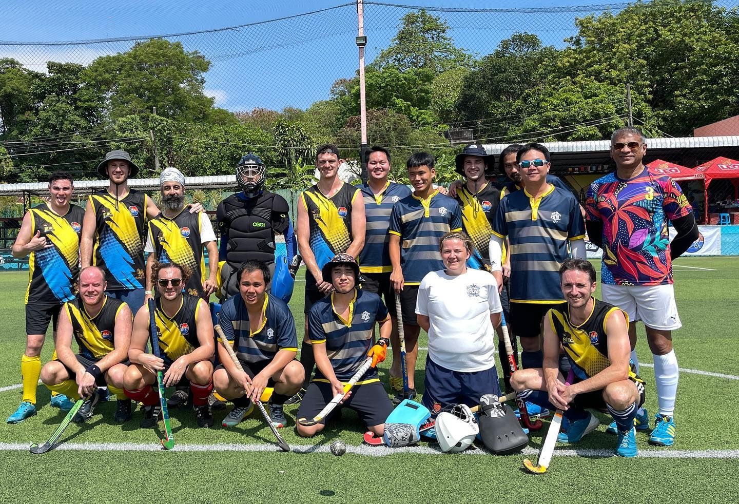 A group of hockey players are posing for a picture on a field.