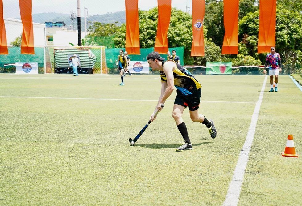 A man is playing field hockey on a field