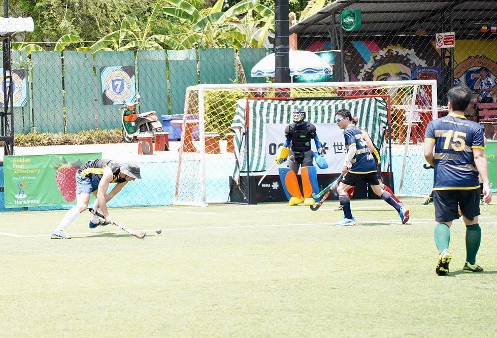 A group of people are playing a game of soccer on a field.