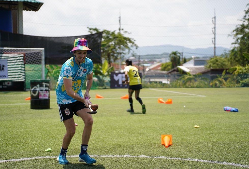 A man and a woman are playing frisbee on a soccer field.