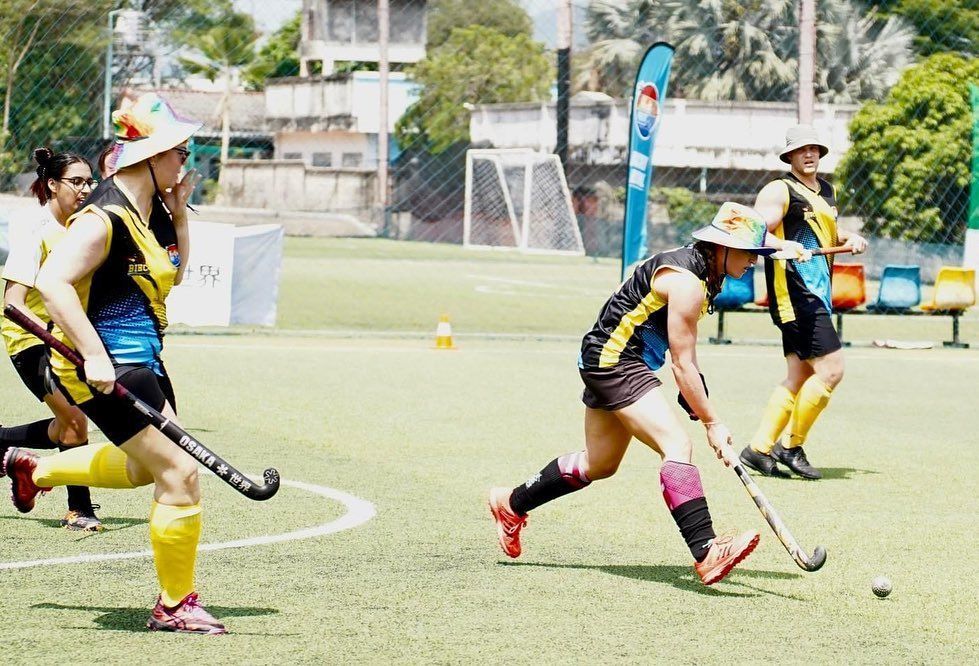 A group of people are playing field hockey on a field