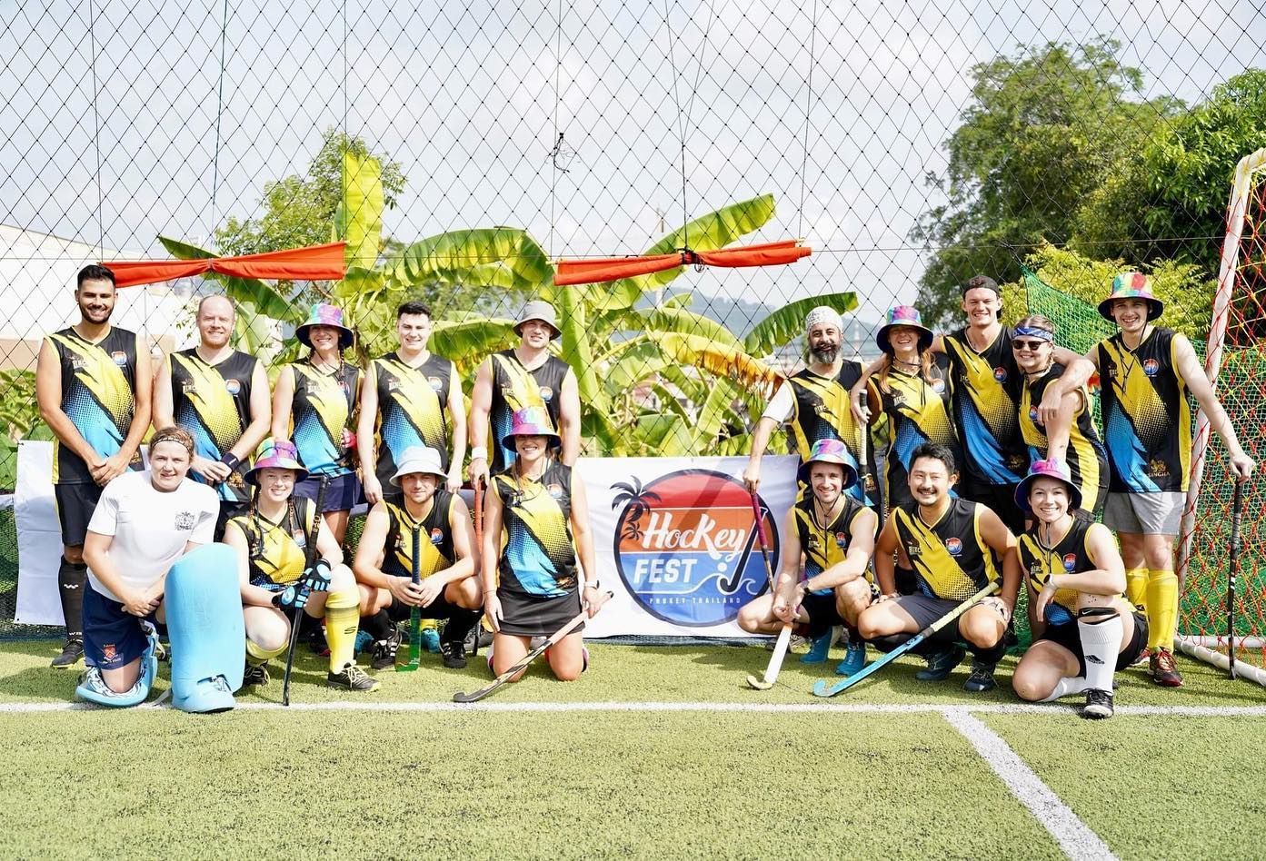 A group of hockey players are posing for a picture on a field.