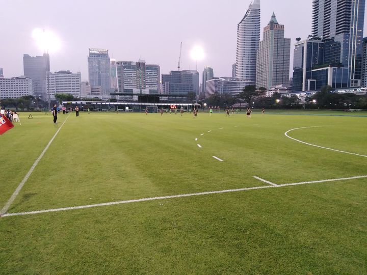 A soccer field with a city skyline in the background