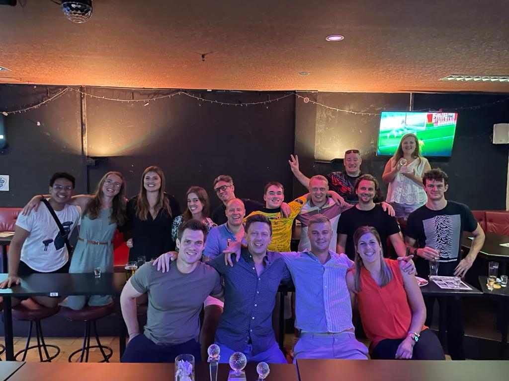 A group of people are posing for a picture in a bar.