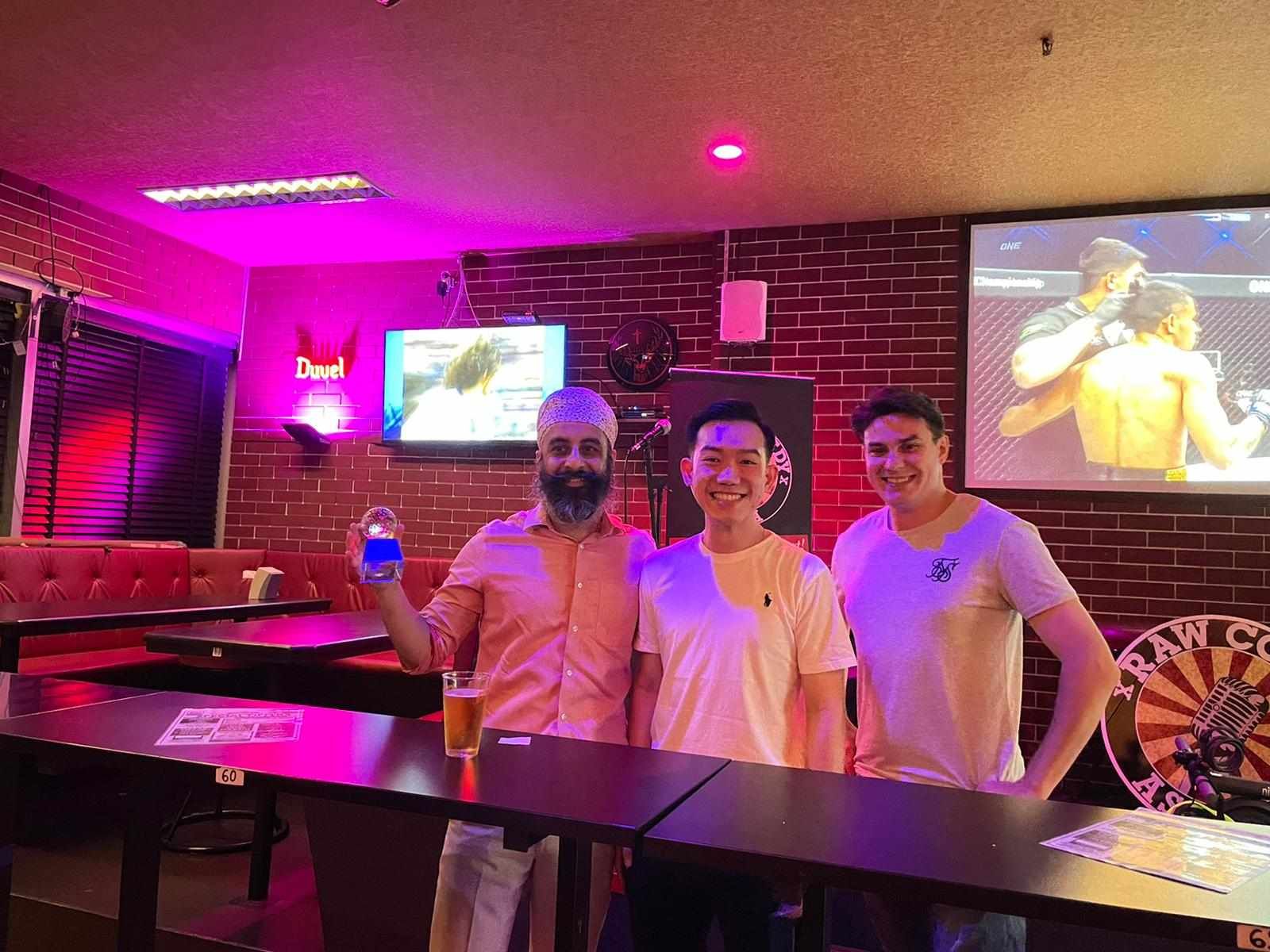 Three men are posing for a picture in a bar.
