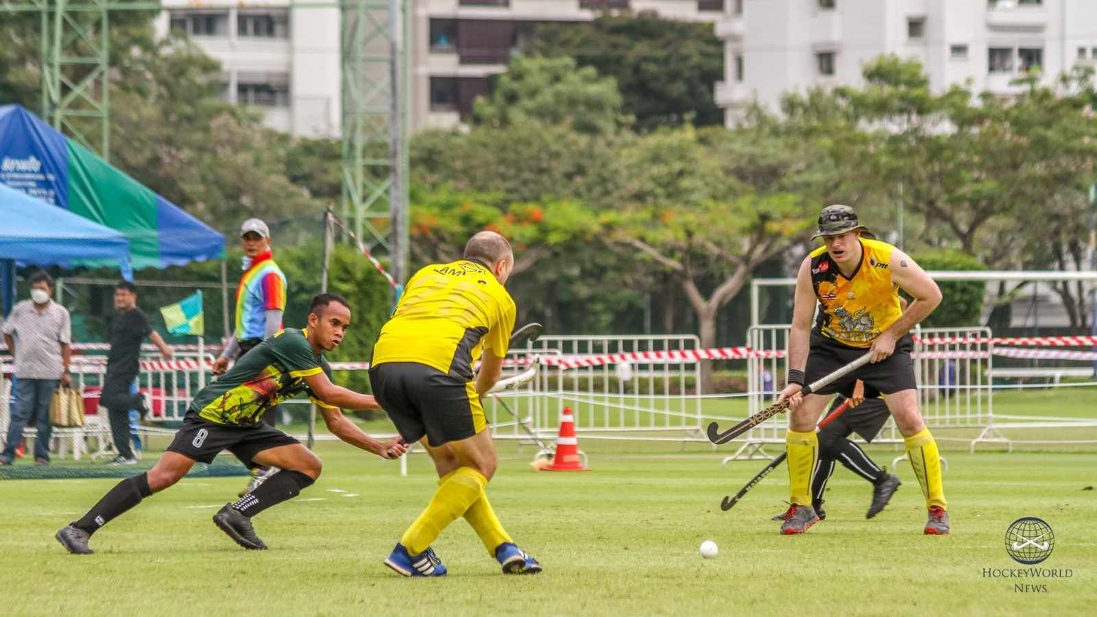 A group of men are playing field hockey on a field.