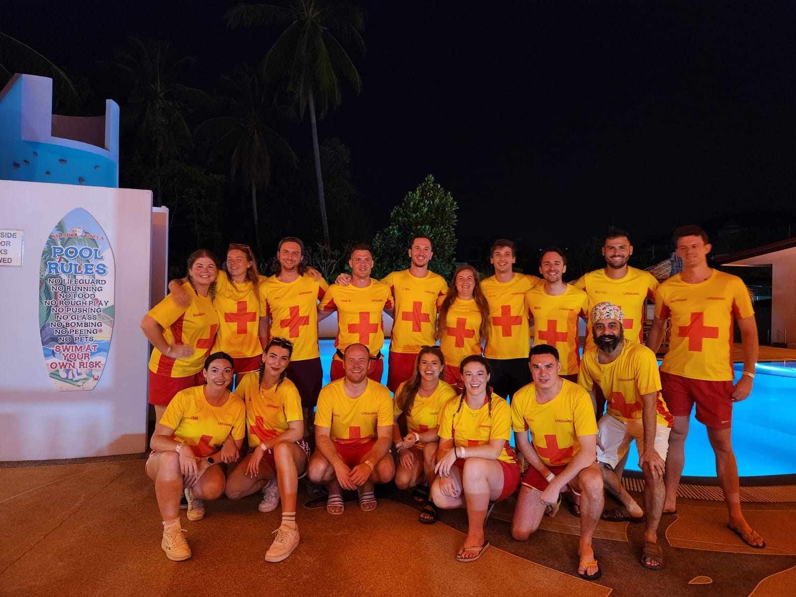 A group of people wearing yellow shirts with crosses on them are posing for a picture.