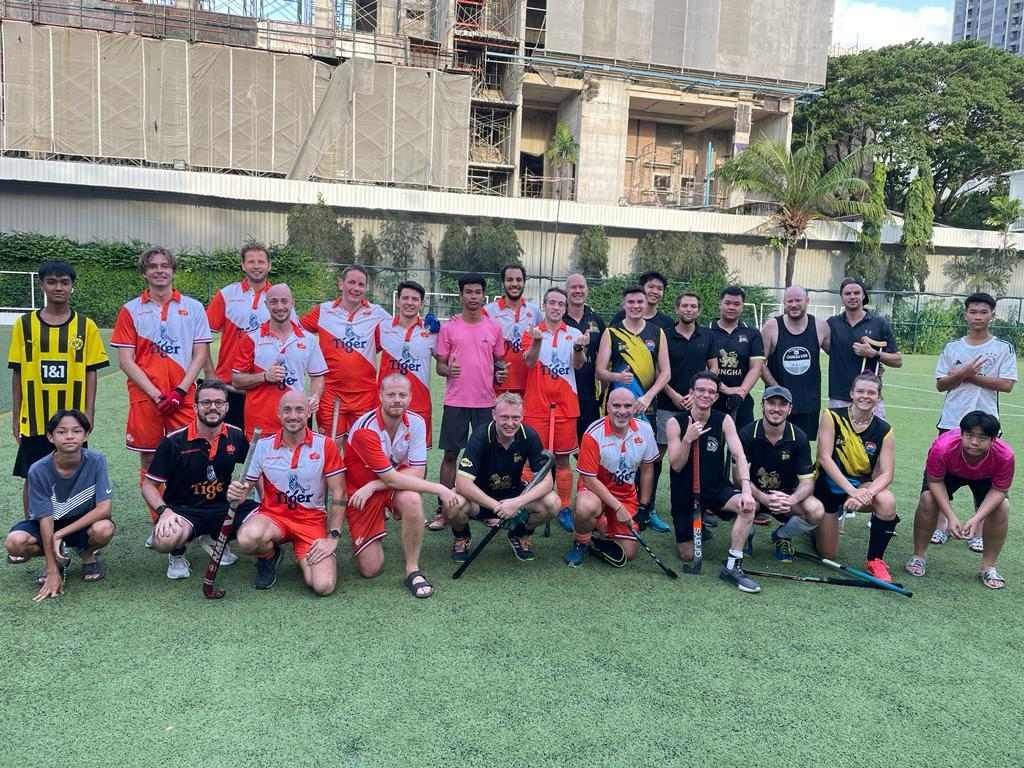 A group of men are posing for a picture on a field.