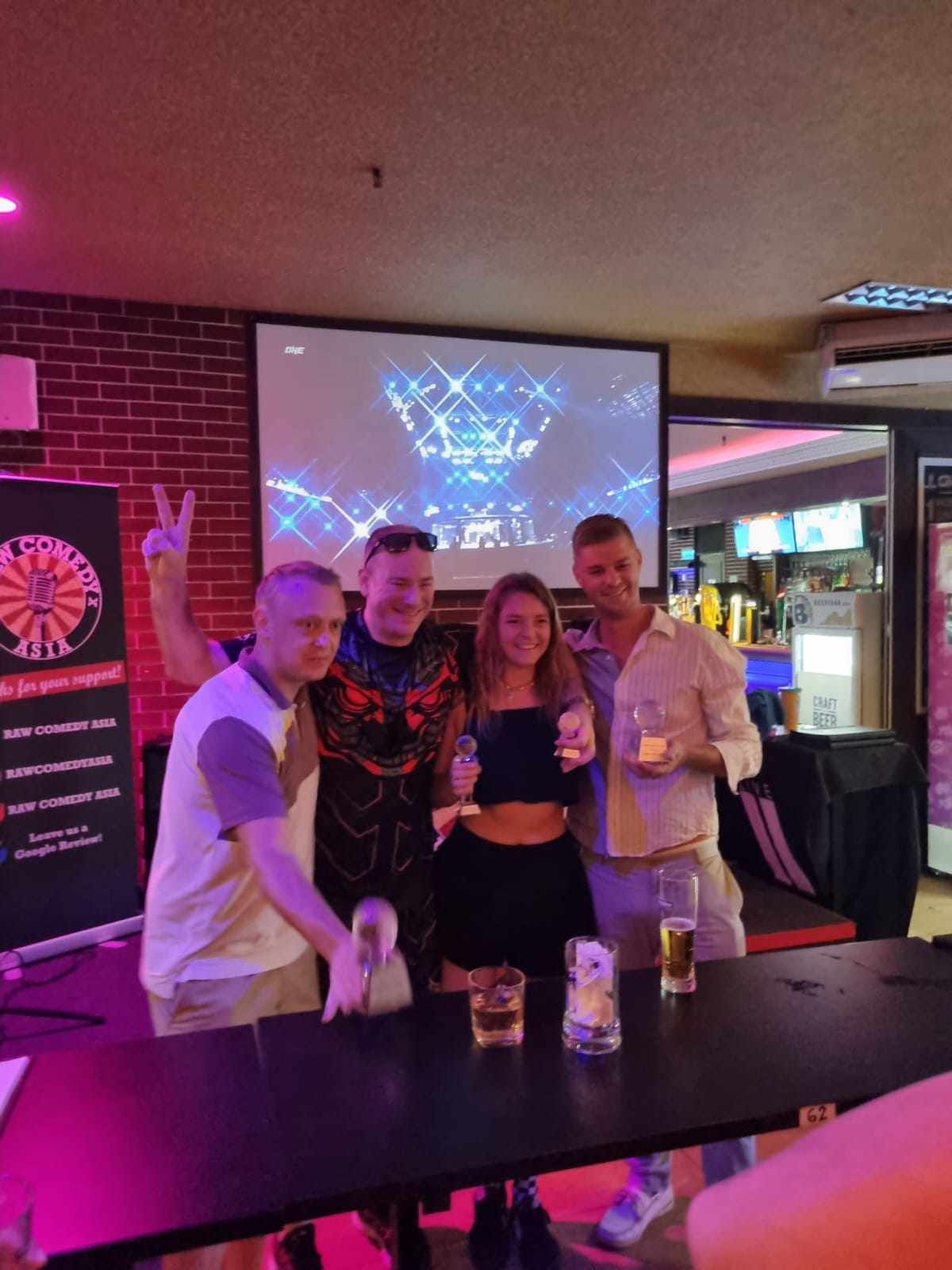 A group of people are posing for a picture in a bar.