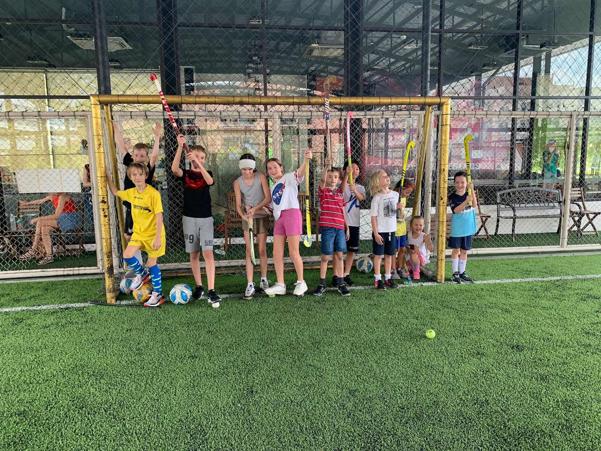 A group of children are posing for a picture on a soccer field.