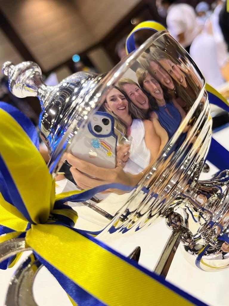 A group of women are taking a picture of themselves in a trophy.