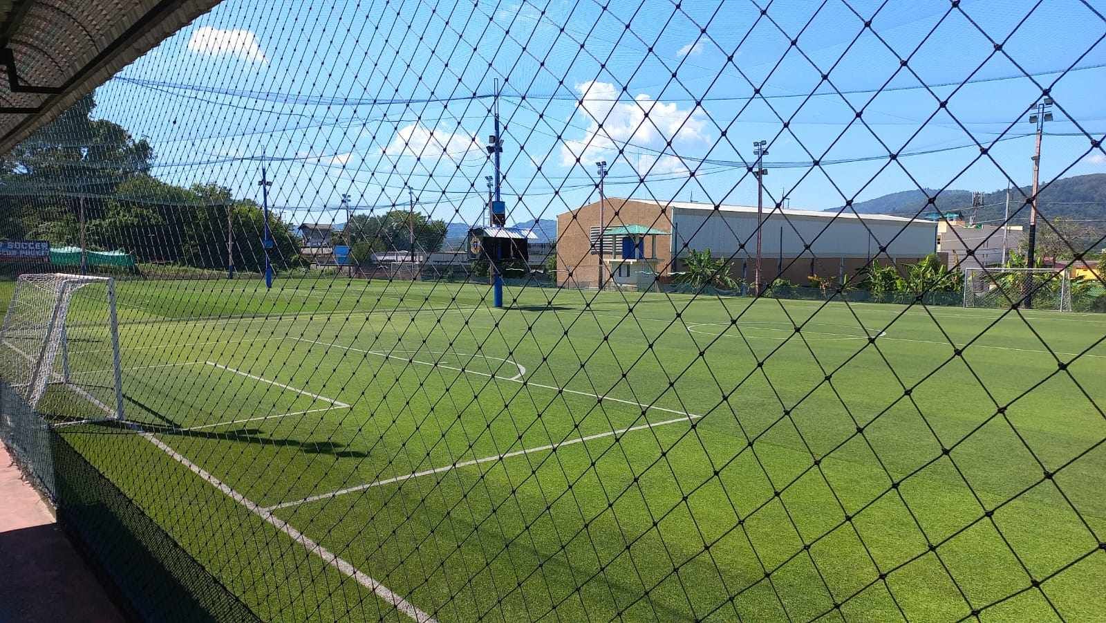 A soccer field is behind a chain link fence.