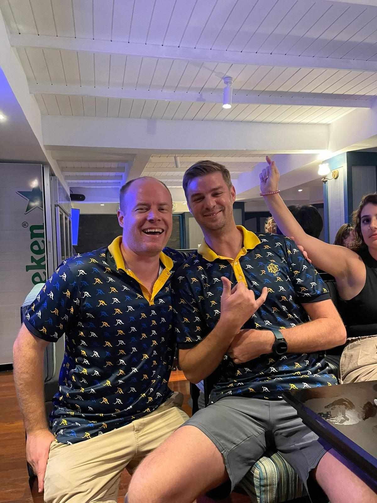 Two men are sitting next to each other in a restaurant.