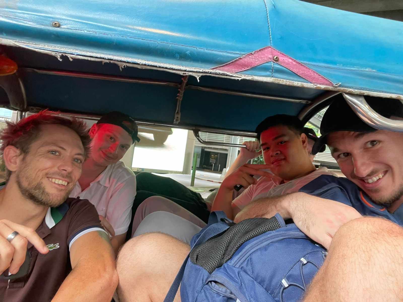 A group of men are sitting in a vehicle and smiling