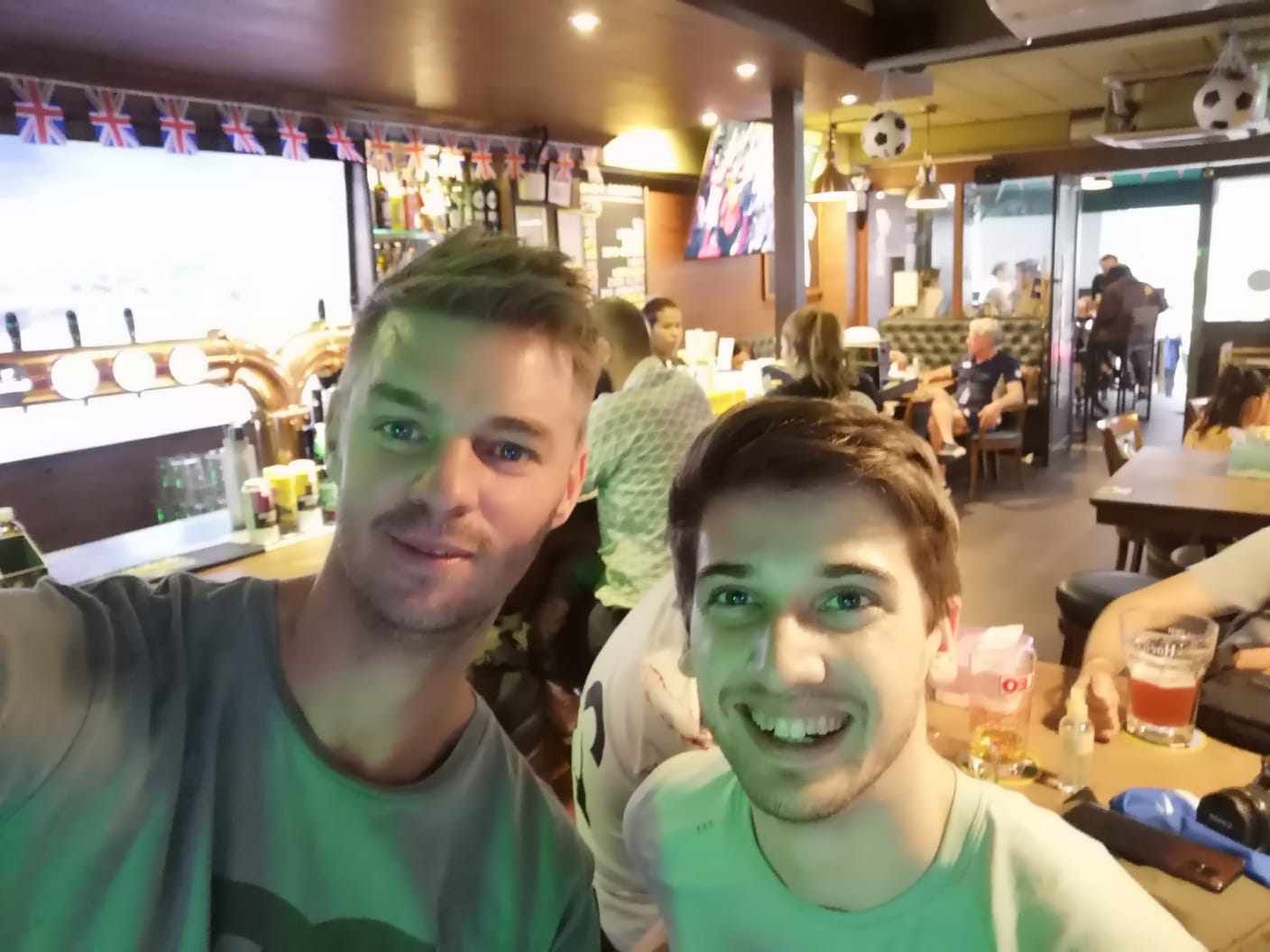 Two men are posing for a picture in a restaurant