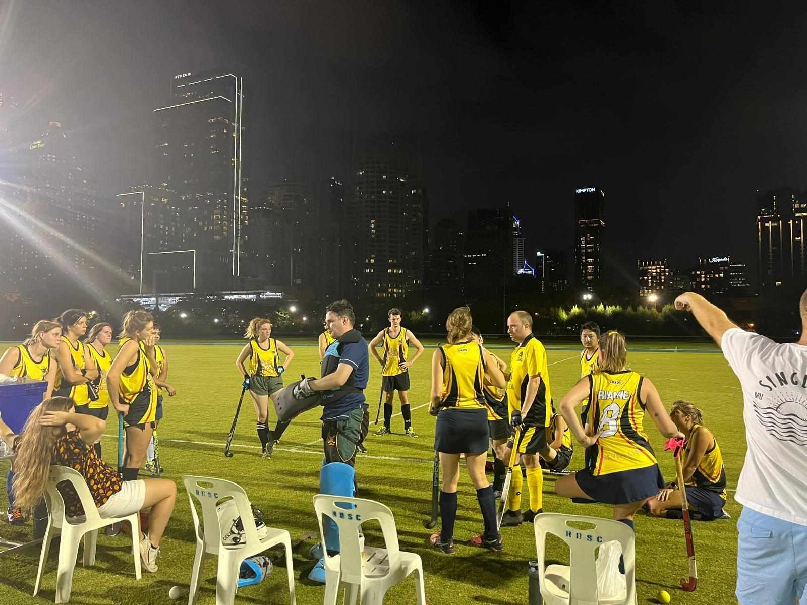 A group of people are standing on a field at night