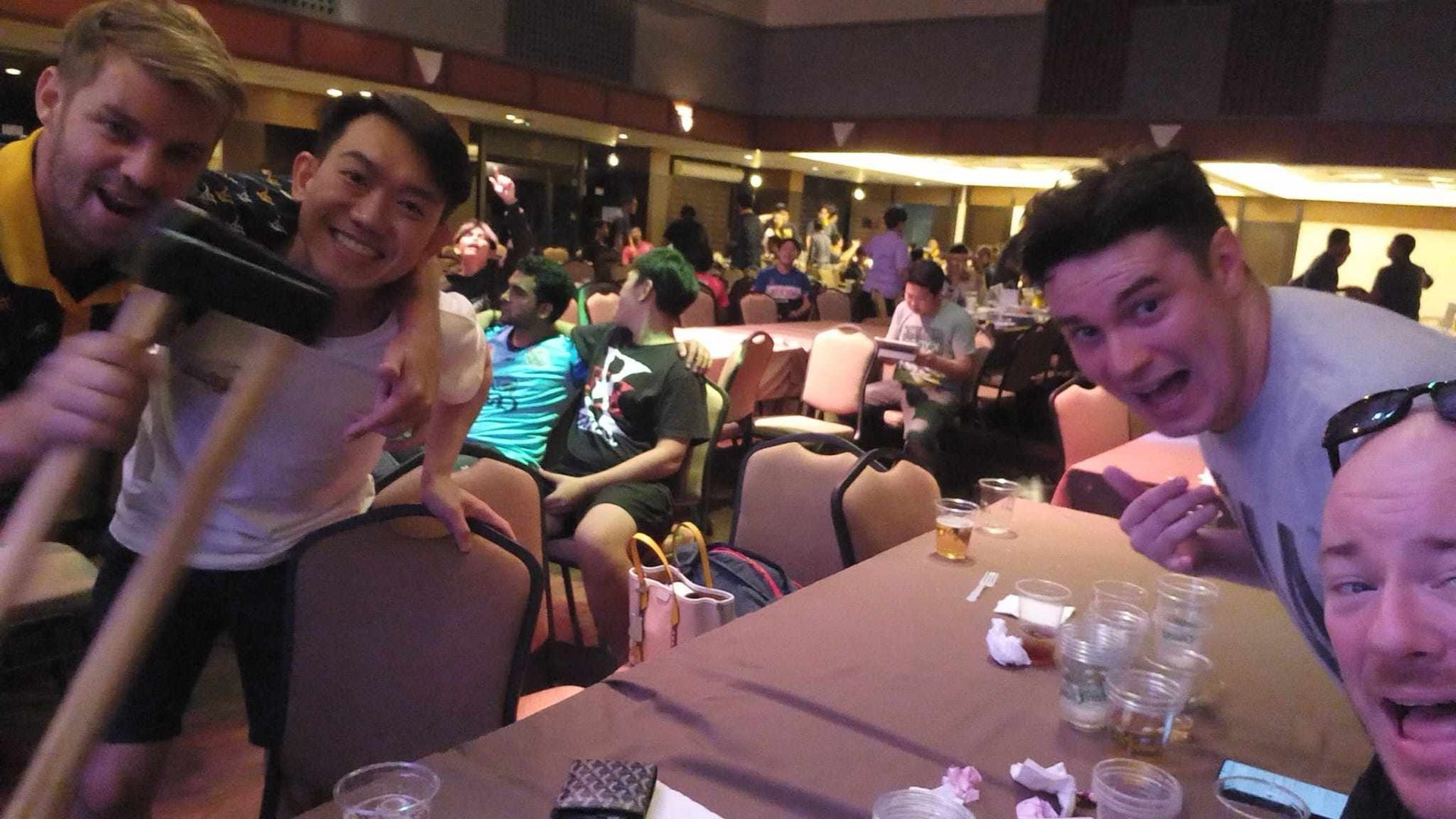 A group of men are posing for a picture while sitting at a table