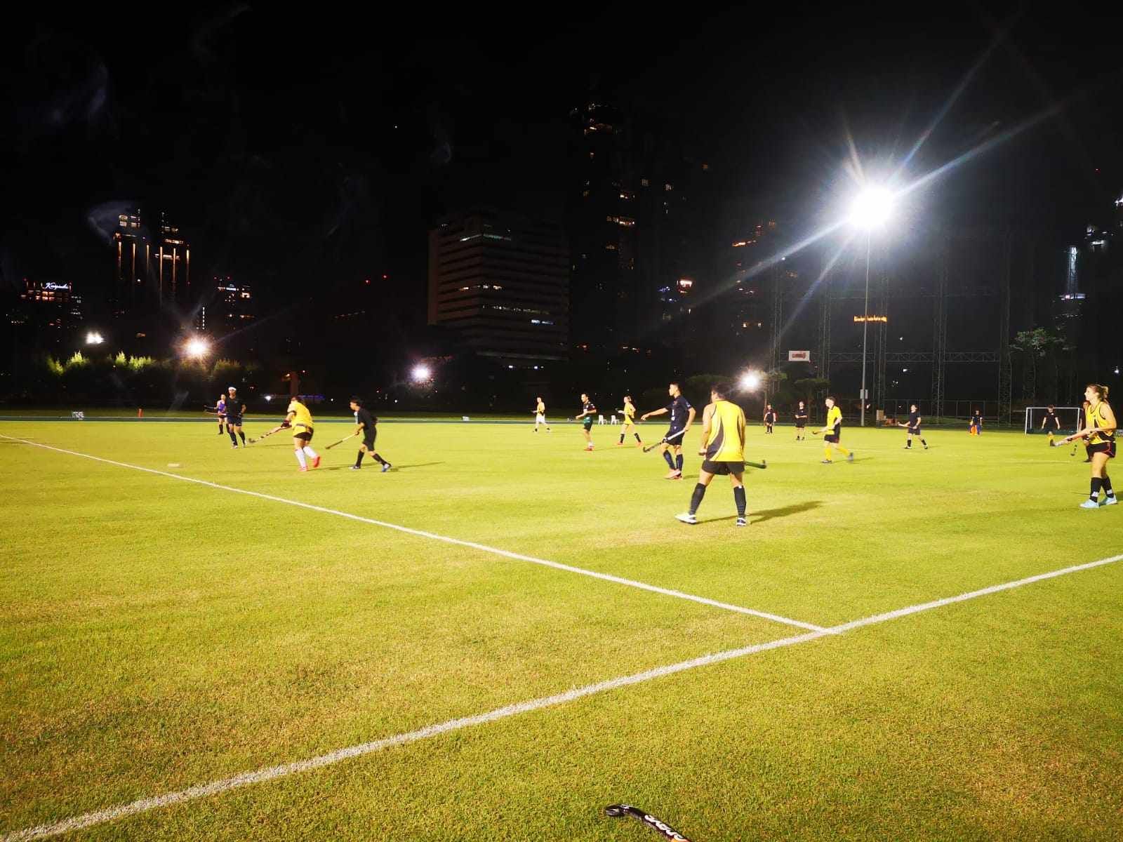 A group of people are playing soccer on a field at night.