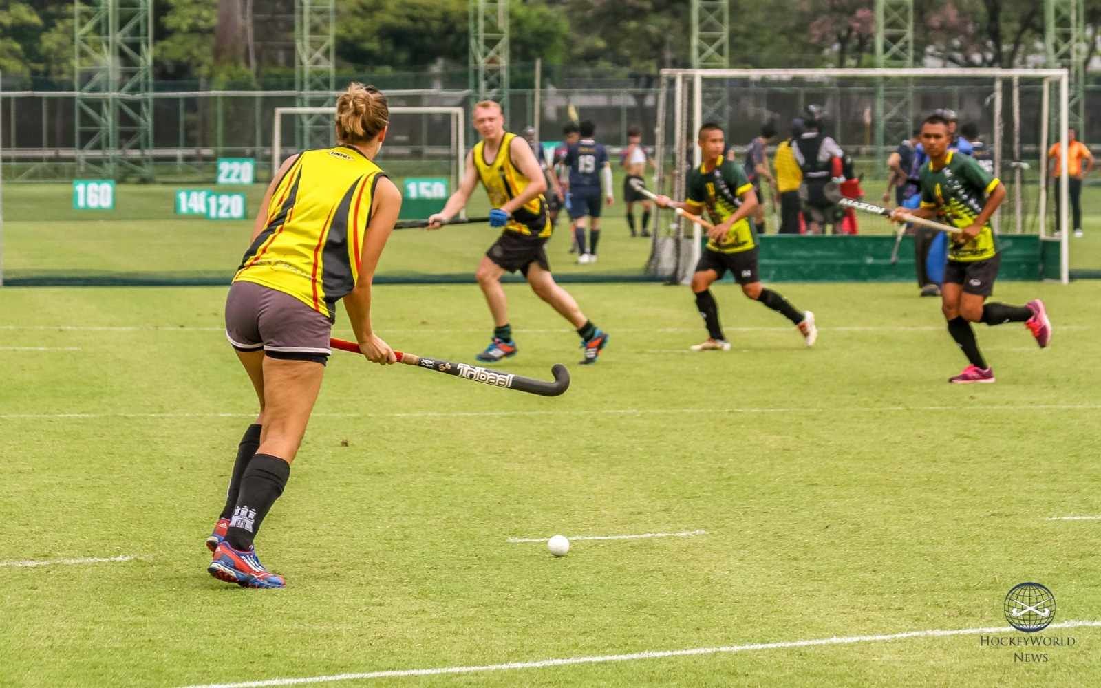 A group of people are playing field hockey on a field.