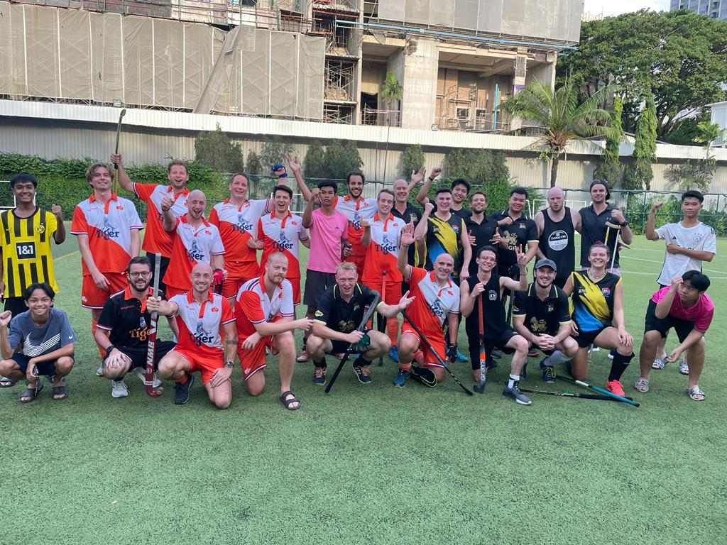 A group of men are posing for a picture on a field.