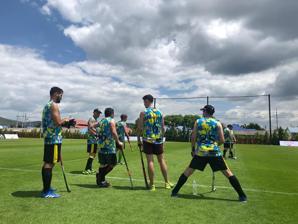 A group of men are playing field hockey on a field.
