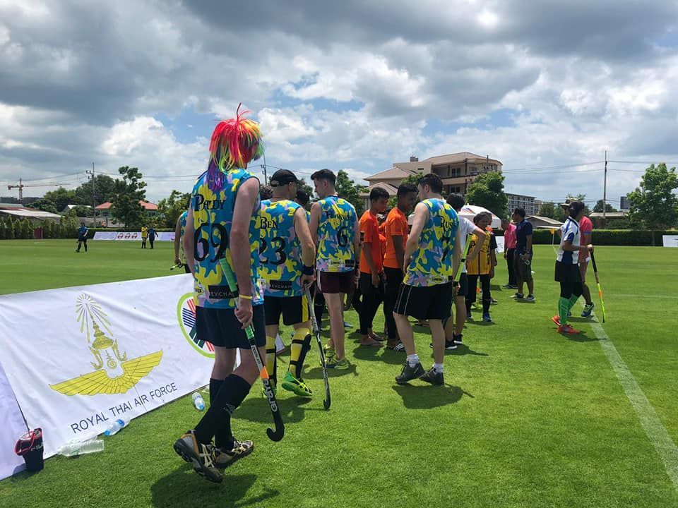 A group of people standing on top of a lush green field.