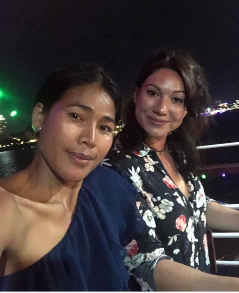 Two women are posing for a picture together at night