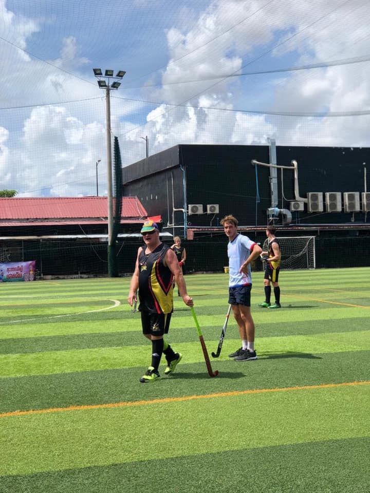 A group of people are playing field hockey on a field.