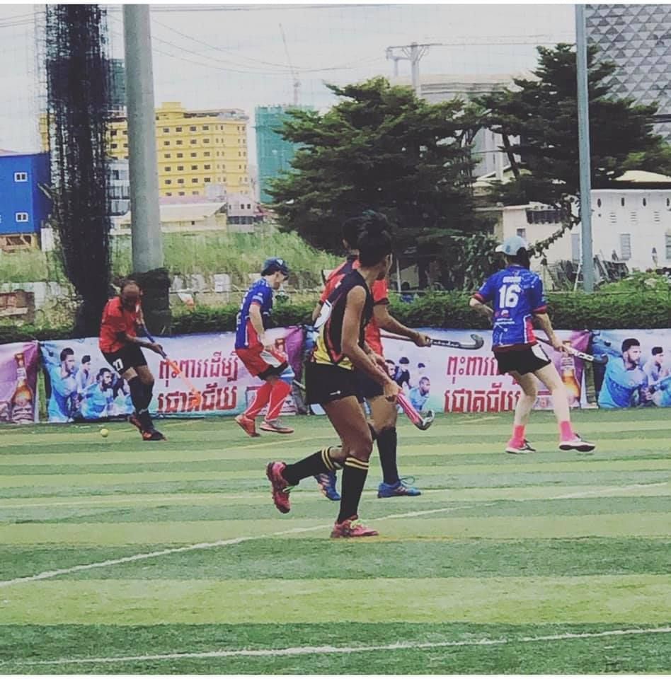 A group of soccer players are playing on a field and one of them has the number 16 on his jersey