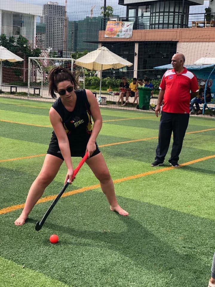 A woman is playing field hockey on a field.
