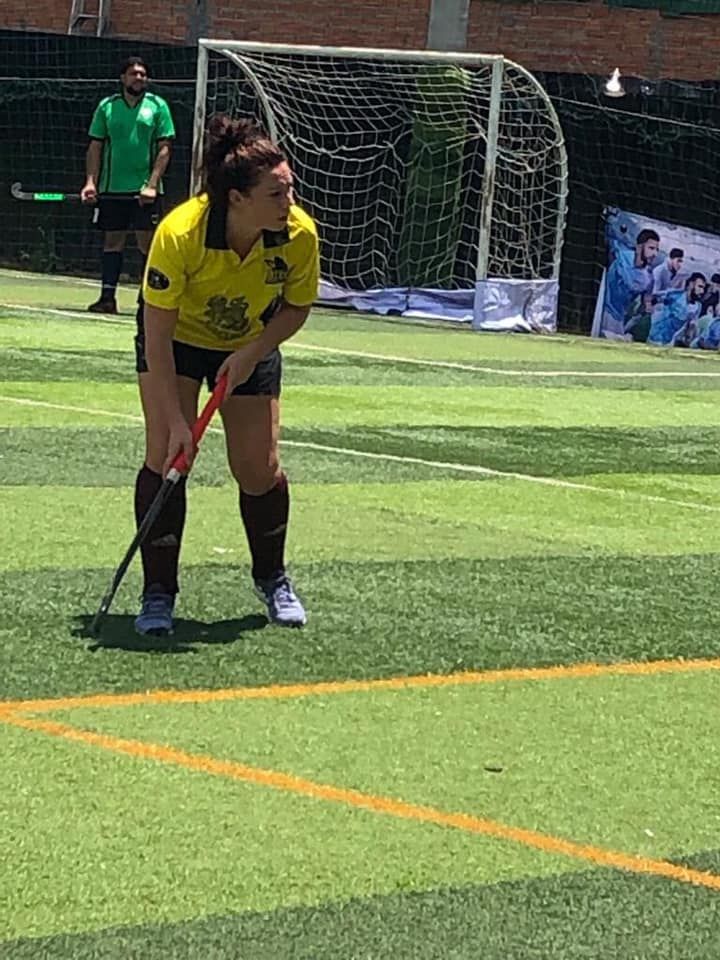 A woman is playing field hockey on a field.