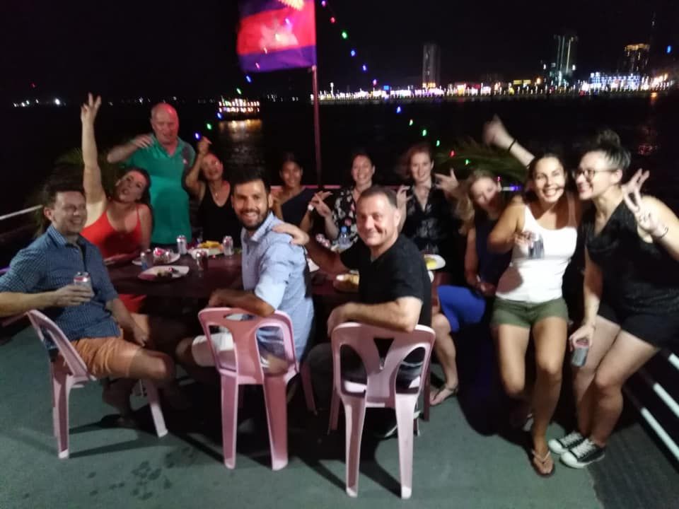 A group of people are posing for a picture while sitting around a table