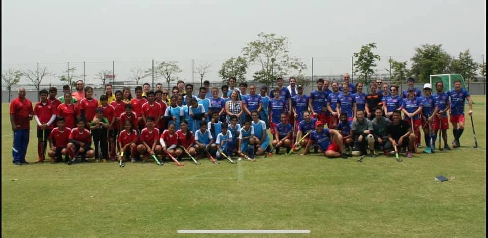 A large group of people are posing for a picture on a field.